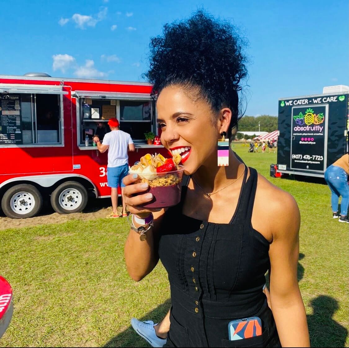 Woman outside smiling eating acai bowl